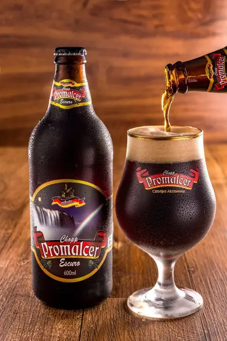 Garrafa de 600 ml do Chopp Promalcer Escuro servido na taça.