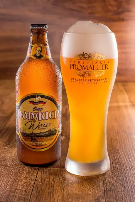 Garrafa de 600 ml do Chopp Donauer Weiss servido no copo alto.